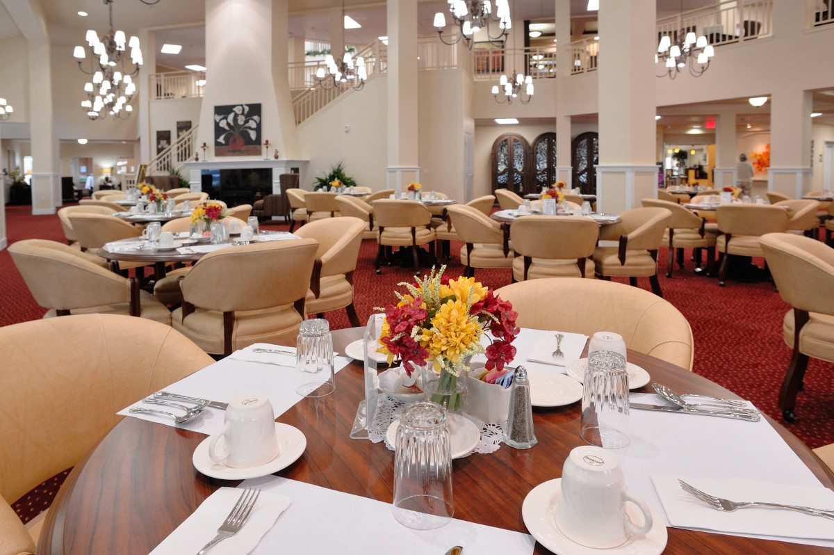 Elegantly set dining area with tables and flower arrangements.