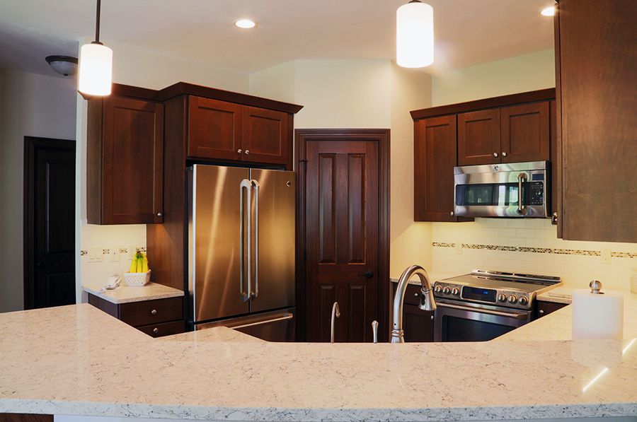 Modern kitchen with stainless steel appliances and wooden cabinets.