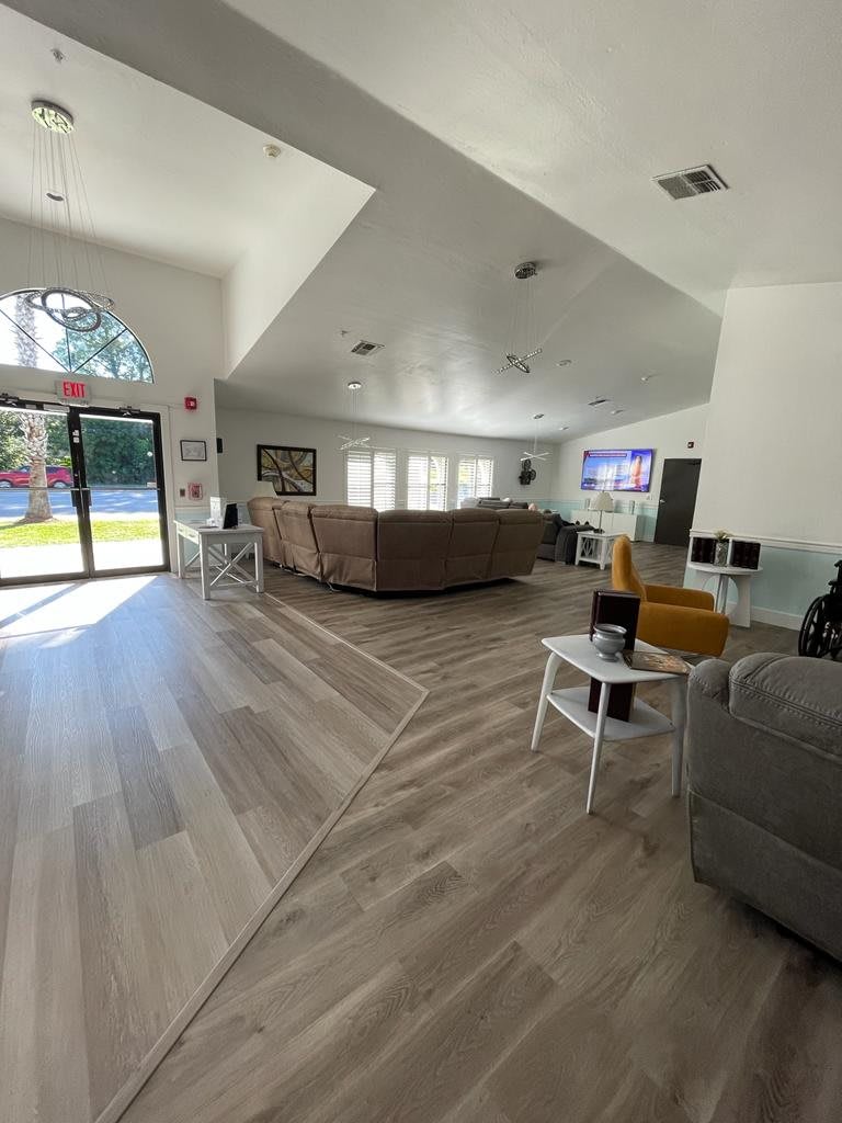 A spacious and bright living room with modern furniture and a large window.