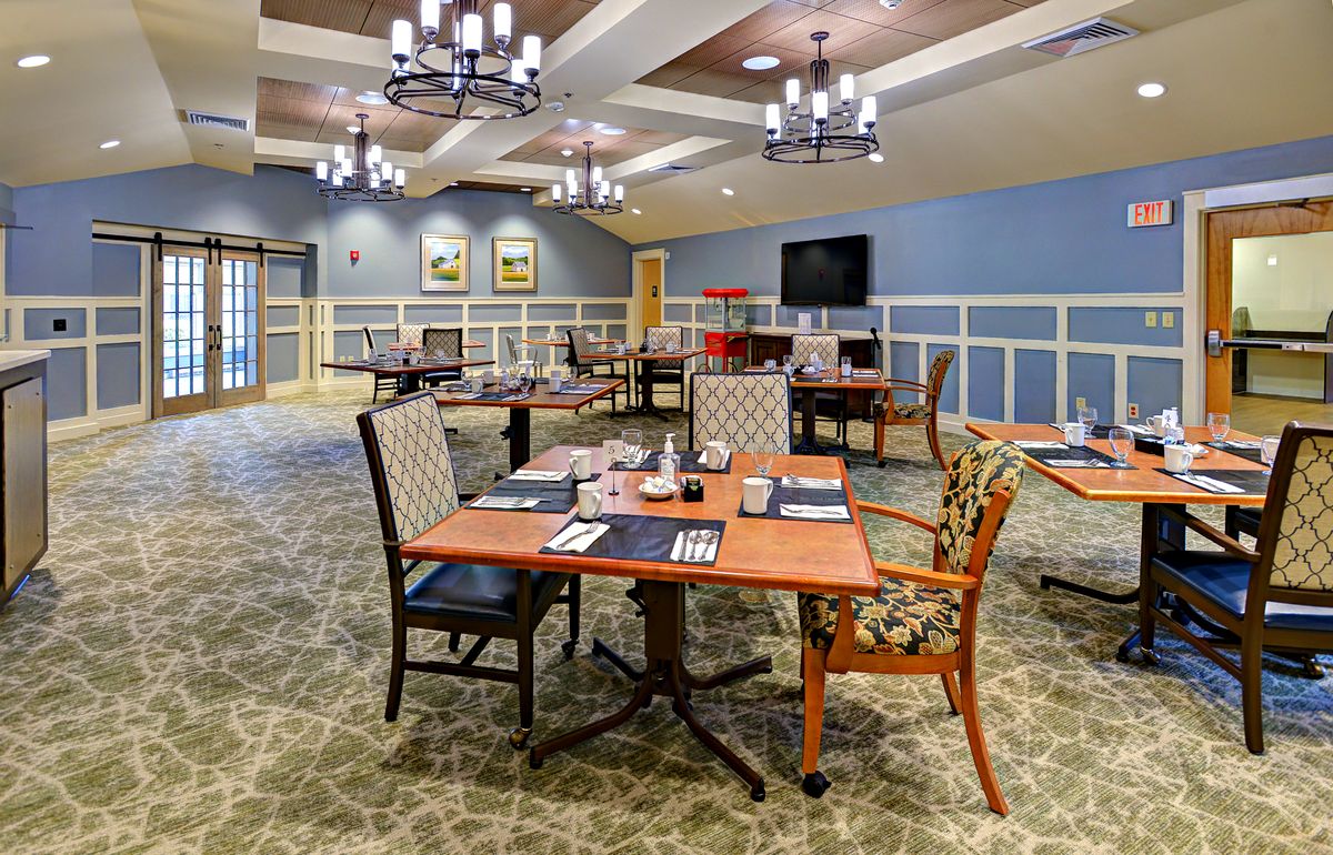 A well-lit and elegantly decorated dining area with neatly arranged tables and chairs.