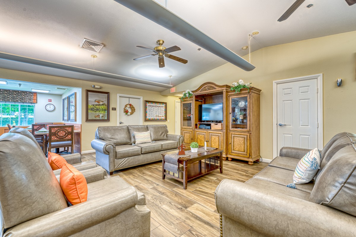 A cozy living room with sofas, a coffee table, and a television in an entertainment cabinet.