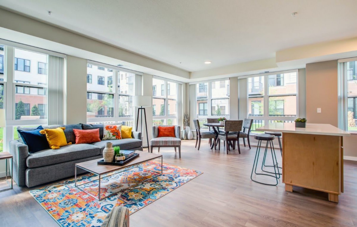 A modern, colorful living room with large windows and open space.