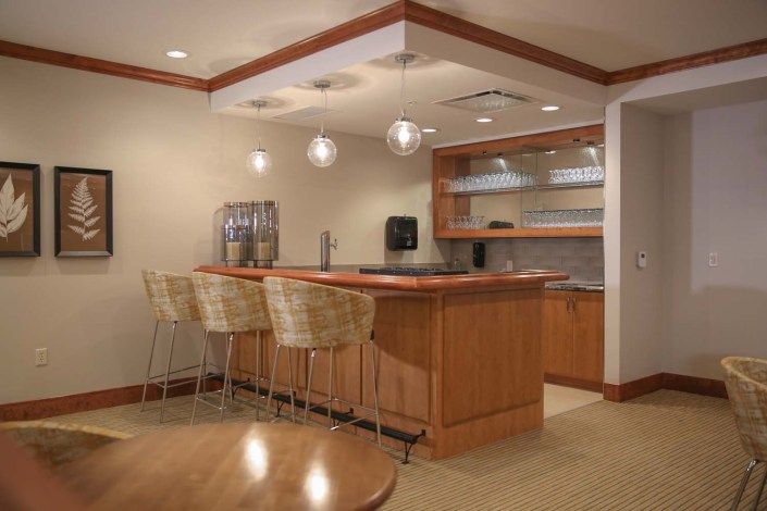 A modern kitchen bar area with a wooden countertop and seating.