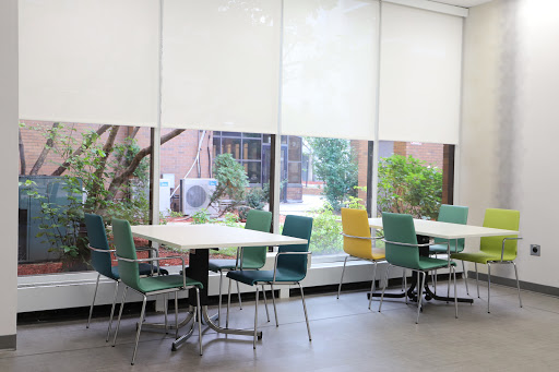 A bright and spacious break room featuring modern furniture and a view of greenery outside.