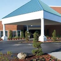 A commercial building with a covered entryway and landscaped surroundings.