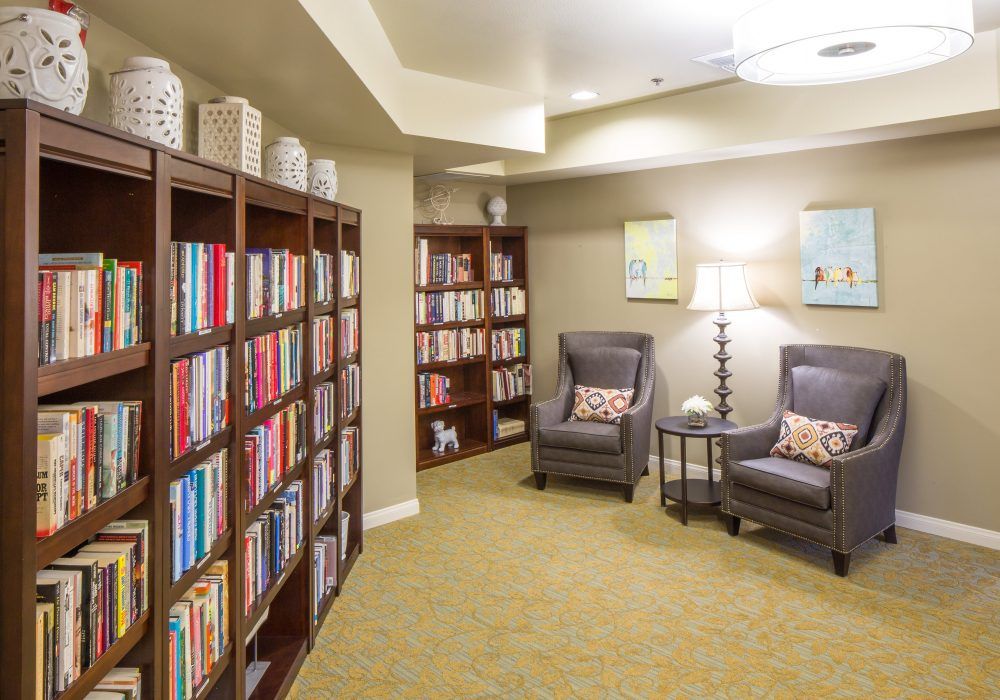 A cozy reading area with bookshelves and armchairs.