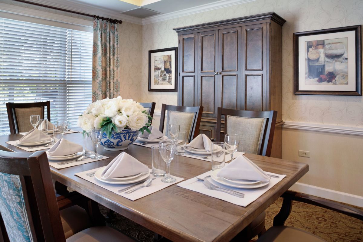 An elegantly set dining room table with flowers and place settings.