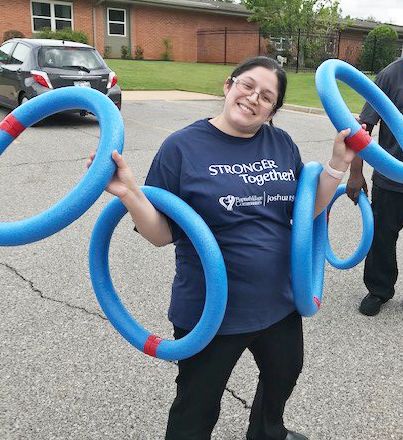 Person holding blue rings outdoors.