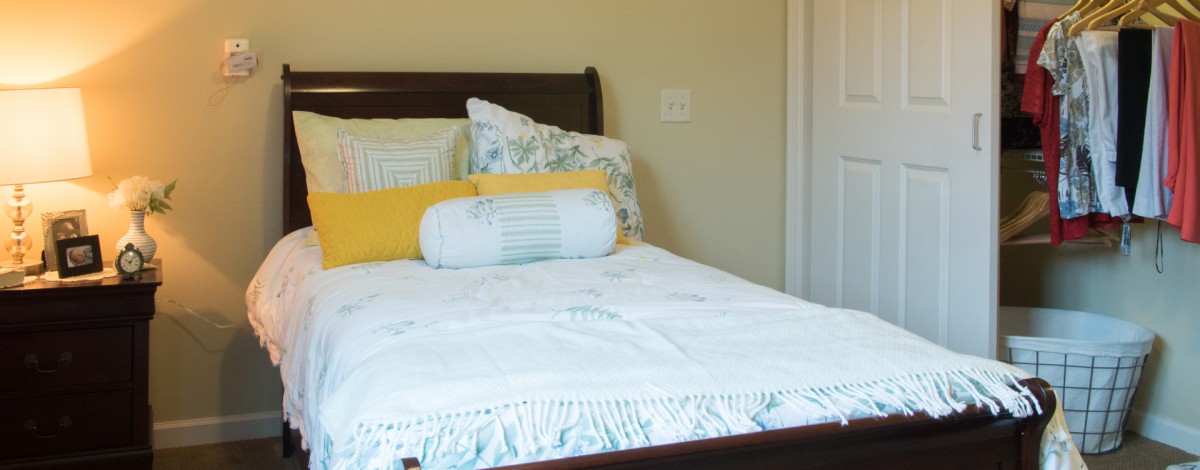 A neatly made bed with colorful pillows in a cozy bedroom.