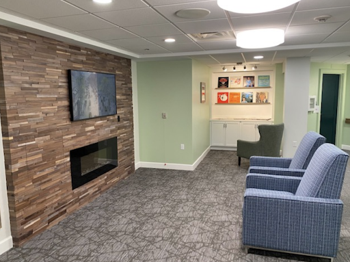 A cozy living room featuring a modern fireplace, a television, and comfortable seating.