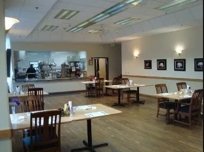 An empty restaurant dining area with neatly arranged tables and chairs.