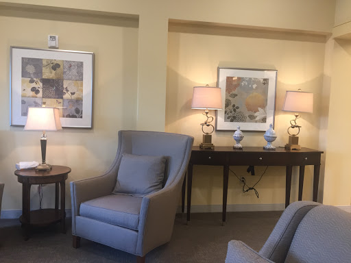 A cozy living space featuring a comfortable armchair, soft lighting, and tasteful artwork.