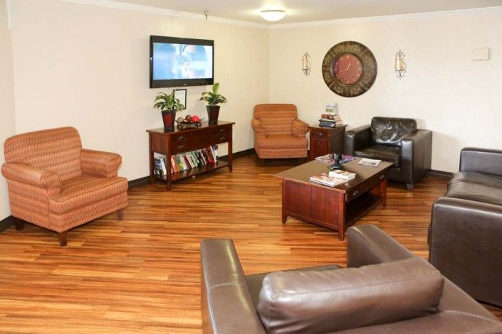 A cozy living room with leather sofas and a wall-mounted television.