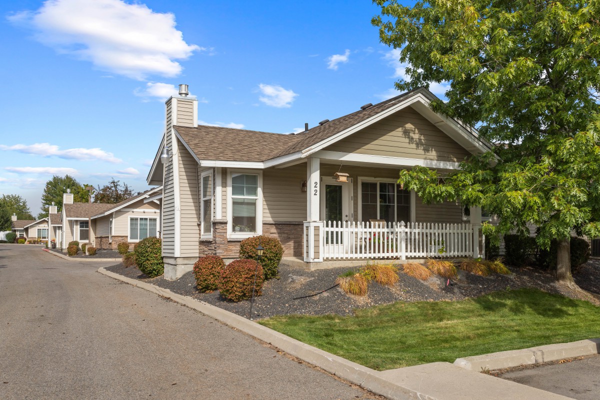 A charming suburban house with a front porch and landscaped yard.