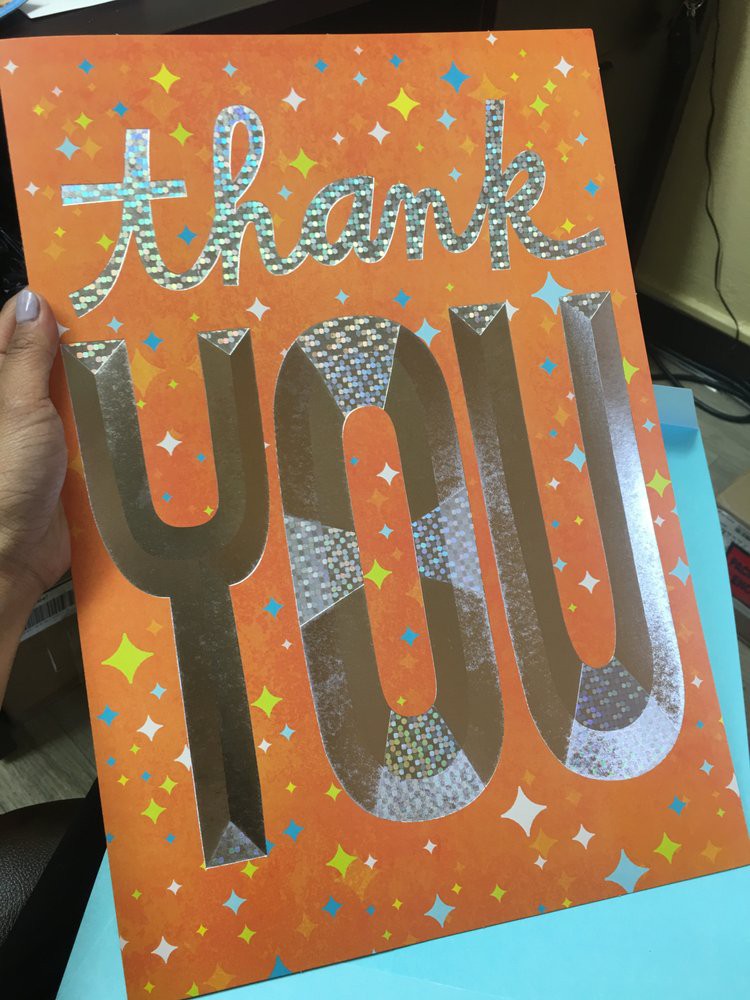 A colorful 'thank you' card with an orange background and decorative text.