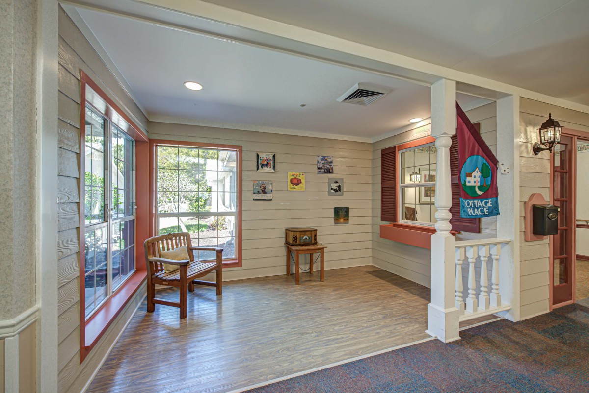 A cozy waiting area with large windows, chairs, and wall decorations.