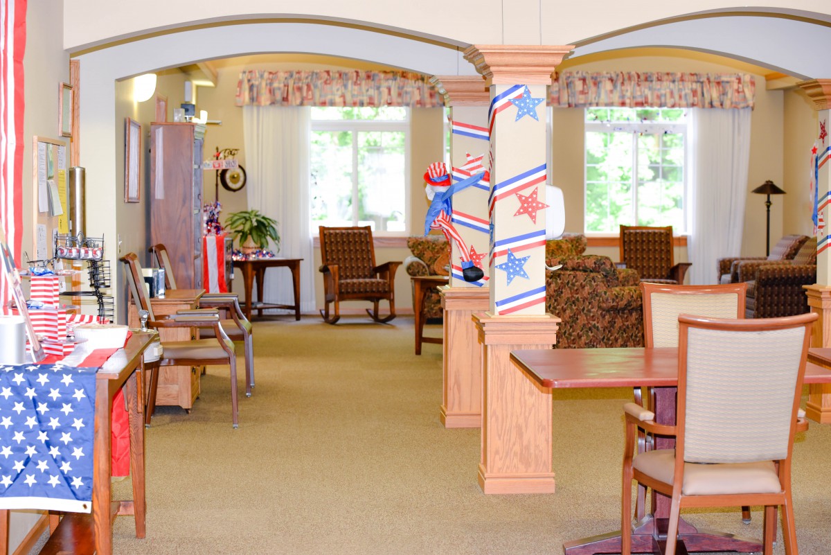 A cozy interior space with tables and chairs, decorated with red, white, and blue stars.
