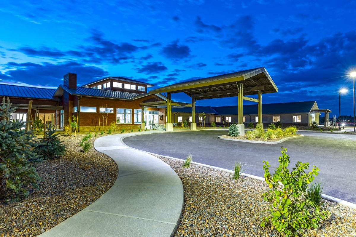 A modern building with a covered entrance at night.