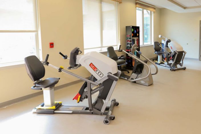 A gym with various exercise machines and equipment for fitness training.
