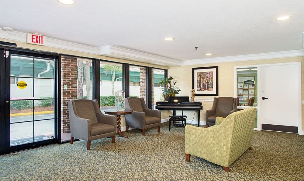 A cozy lobby seating area with armchairs and large windows.