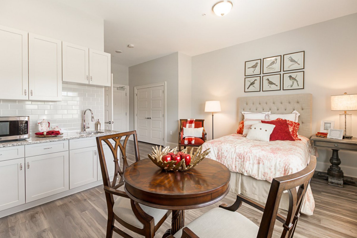 A cozy and modern bedroom with a small dining area, featuring elegant furniture and tasteful decor.