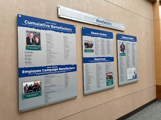 An informational board displaying various employee benefits and recognitions.