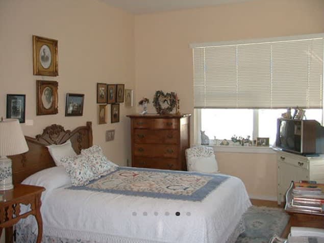 A cozy bedroom with a single bed, decorated with framed pictures and a chest of drawers.