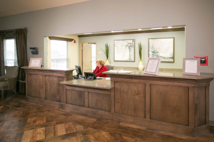A welcoming reception area with a front desk and a staff member working.