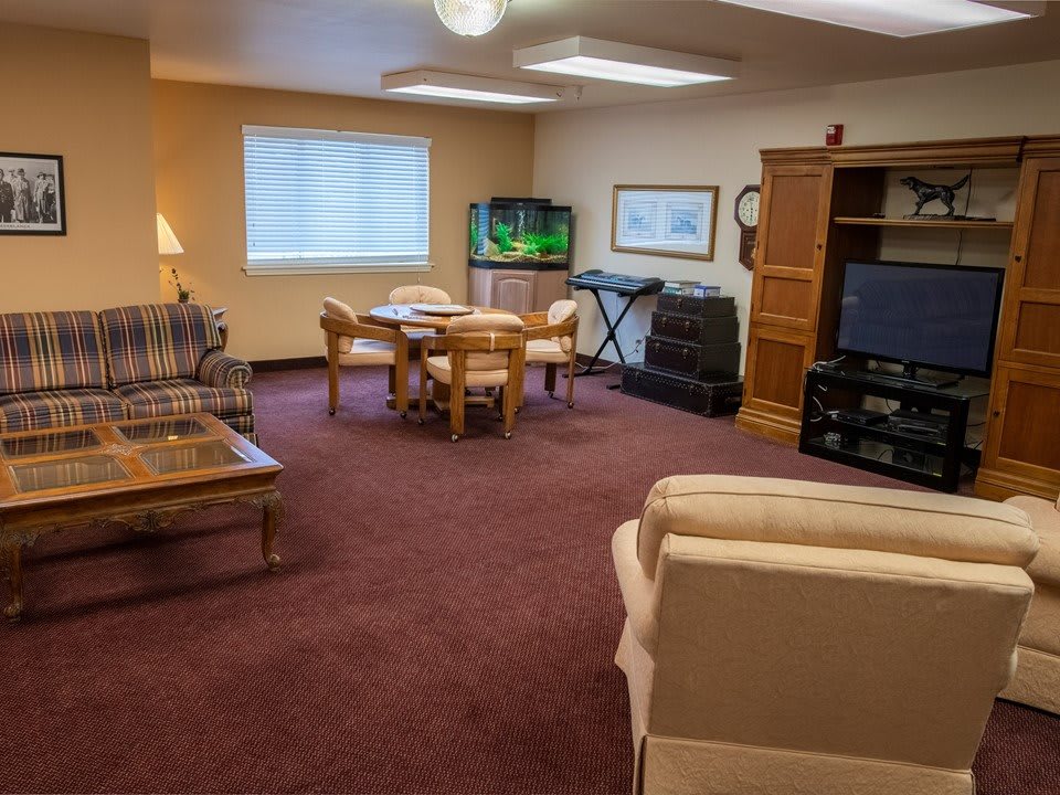 A cozy living room with comfortable seating, a TV, and a fish tank.