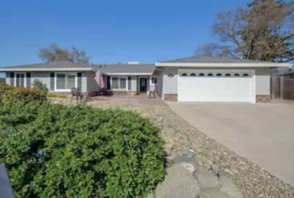 A suburban single-story house with a garage and driveway.