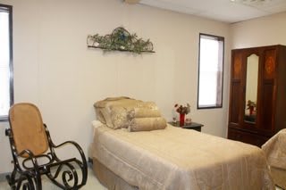 A cozy bedroom with a single bed and a rocking chair.