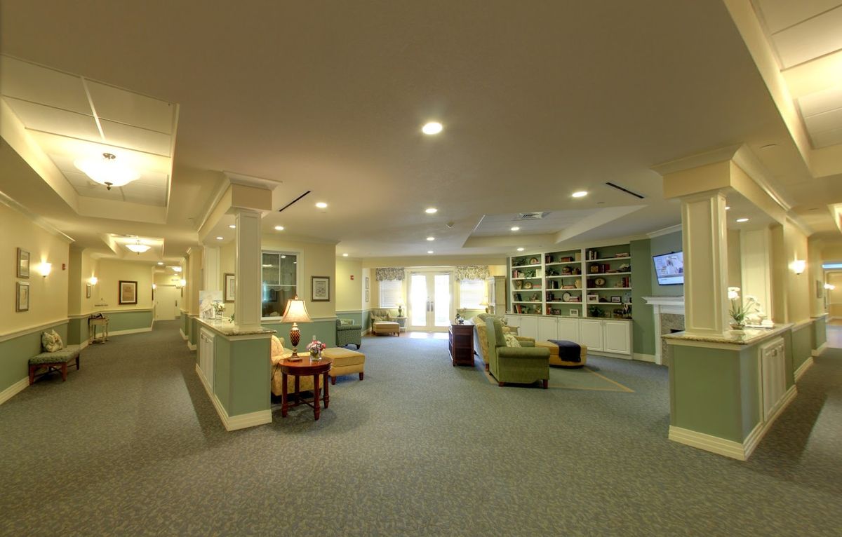 A spacious and well-lit lobby area with comfortable seating and carpeted flooring.
