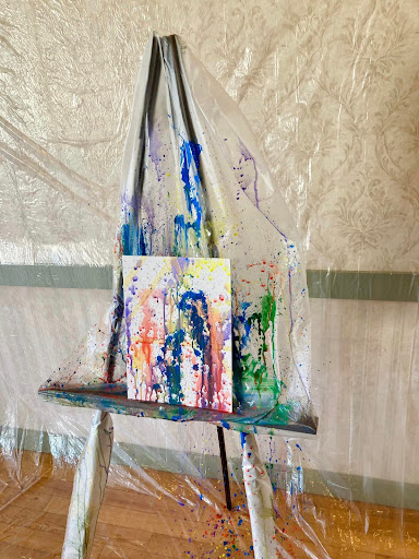 A vibrant abstract painting displayed on an easel in a creative workspace.