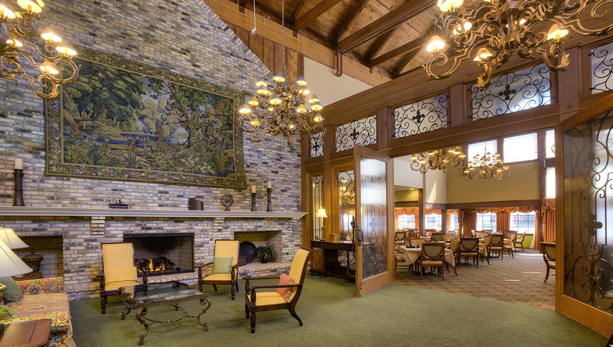 Cozy rustic lounge with a fireplace, wooden beams, and comfortable seating.