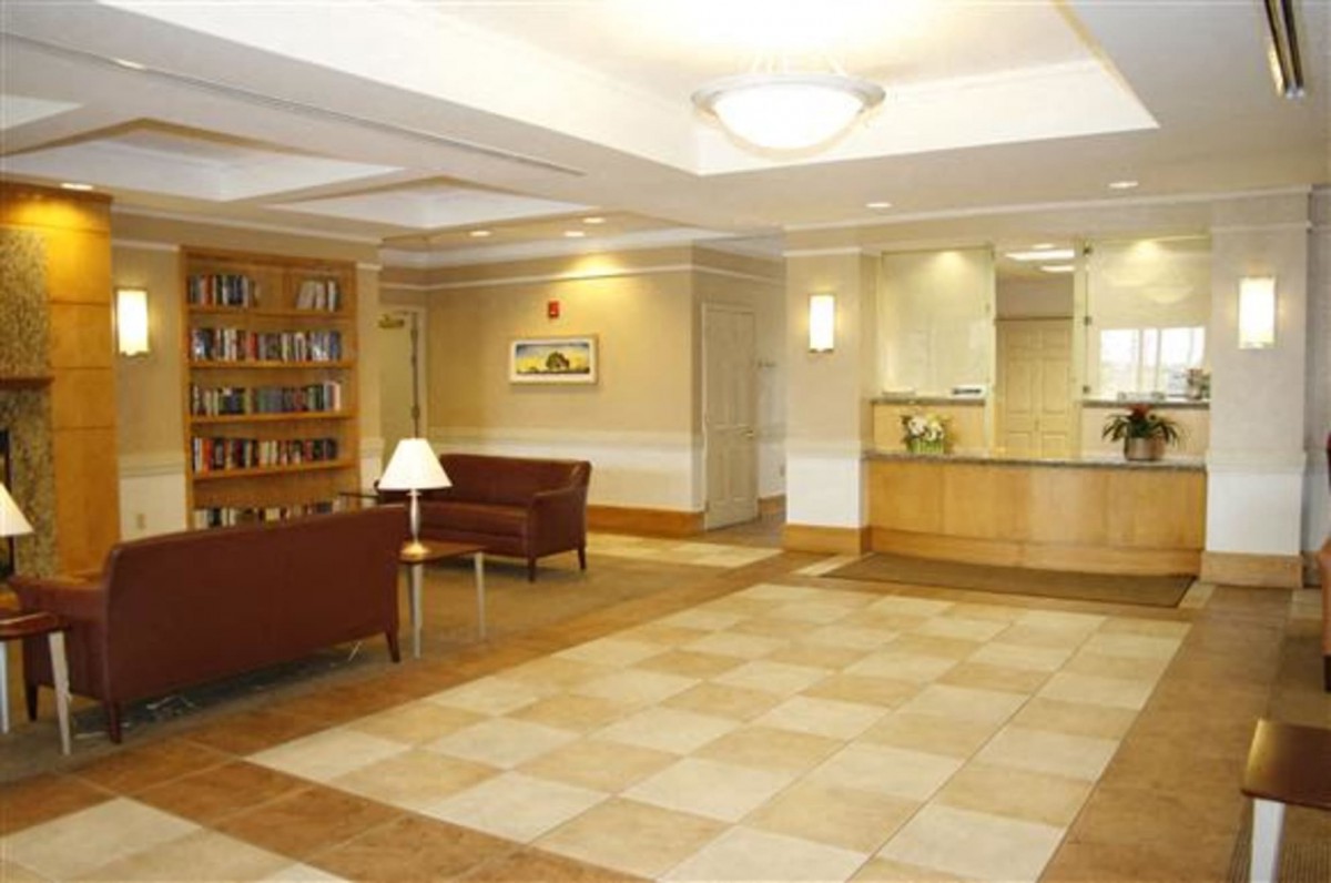 A spacious and well-lit reception area with comfortable seating and a bookshelf.