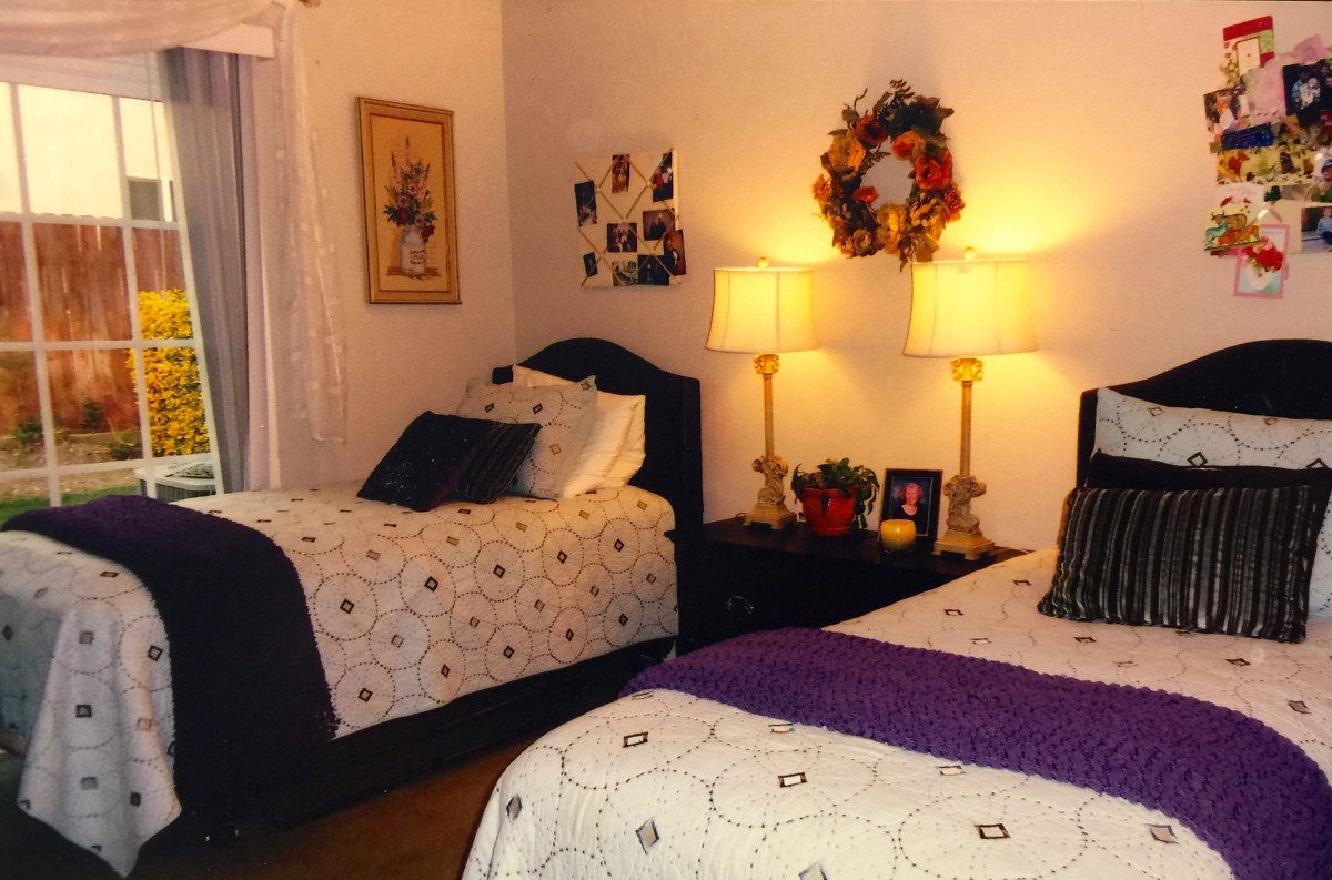 A cozy bedroom with two neatly made beds and warm lighting.