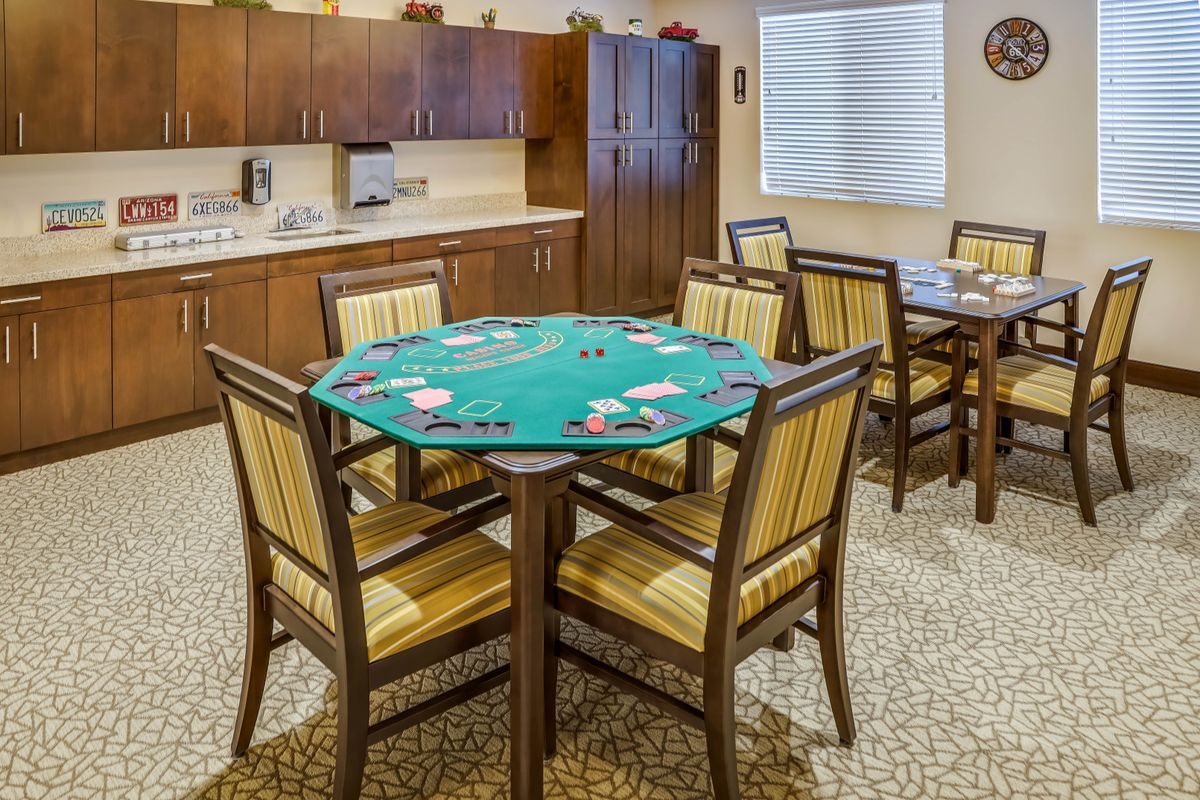 A cozy game room featuring a poker table surrounded by chairs, perfect for card games and social gatherings.