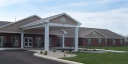 A modern building with a covered entrance and white columns.