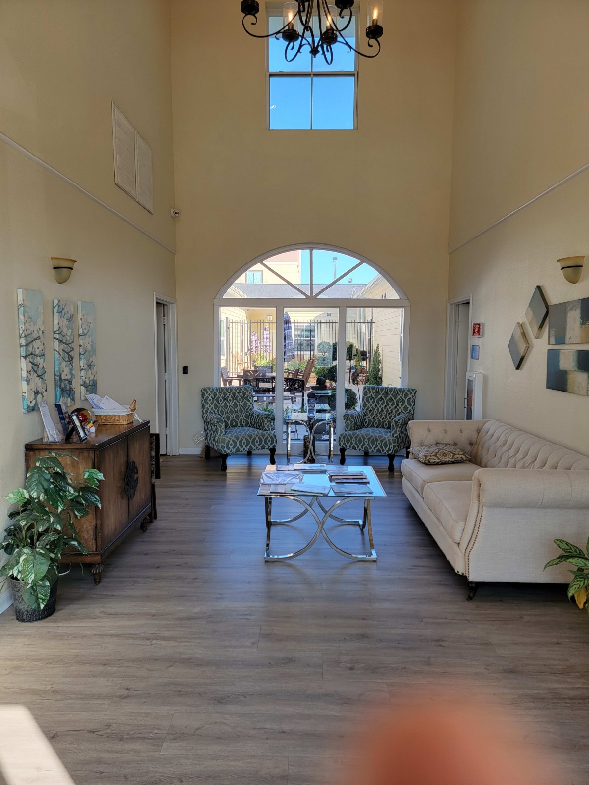 A modern living room with stylish furniture and decor, featuring a sofa, armchairs, and large windows that bring in natural light.