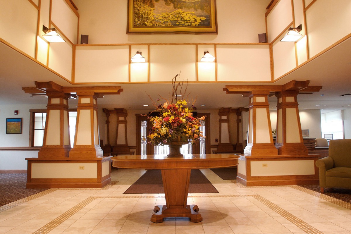 Elegant hotel lobby with a central floral arrangement and warm lighting.