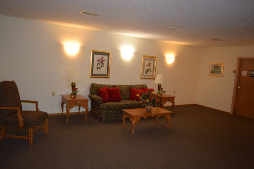 A cozy living room featuring a patterned sofa, coffee tables, and decorative artwork.
