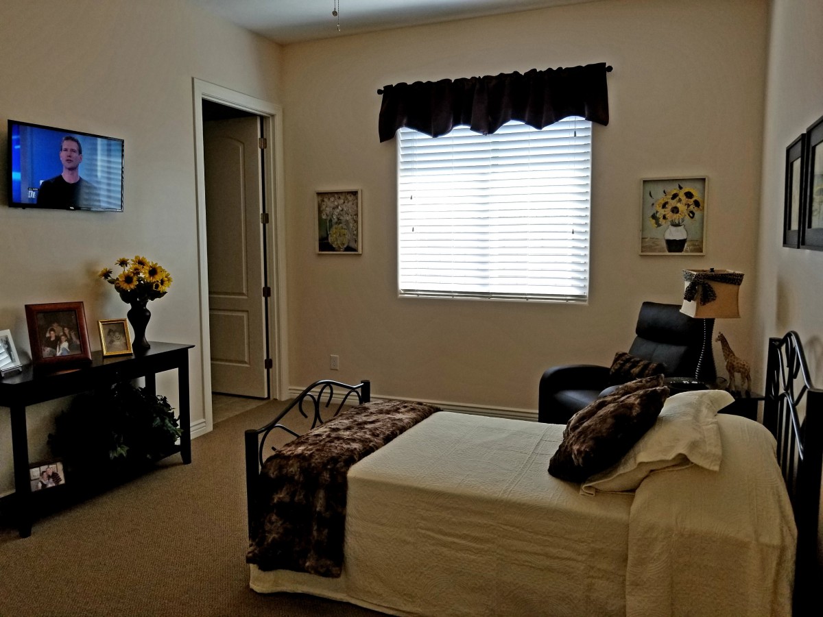 A cozy bedroom interior with a single bed, chair, and window.