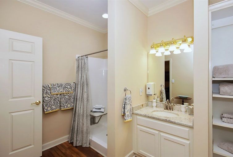 A cozy bathroom featuring a shower, sink with mirror, and neatly arranged towels.
