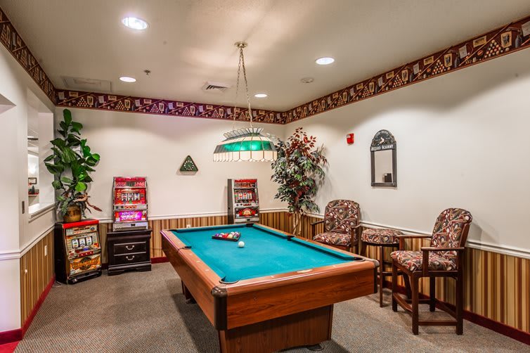 A cozy game room with a pool table and comfortable seating.