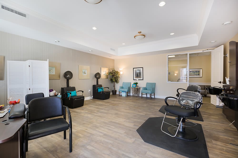 A modern salon interior with seating and hair drying stations.