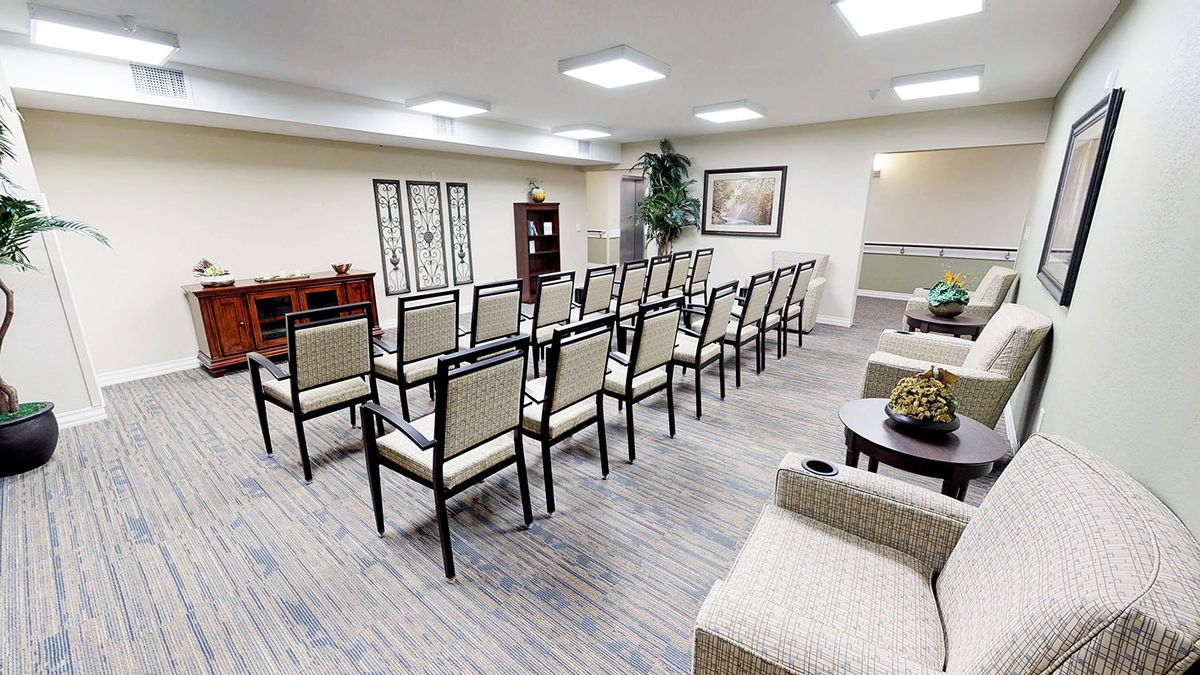 An empty conference room with rows of chairs arranged for a meeting.