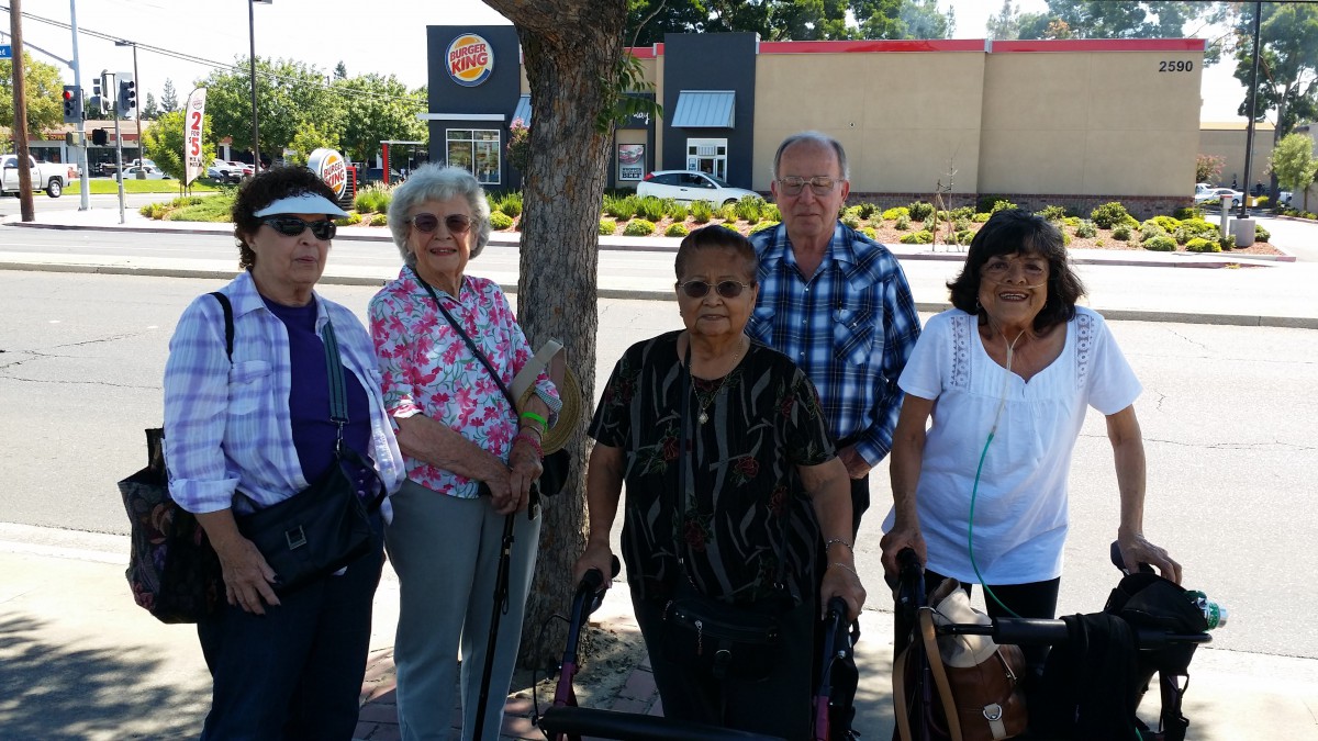 A group of seniors enjoying a sunny day outdoors together.