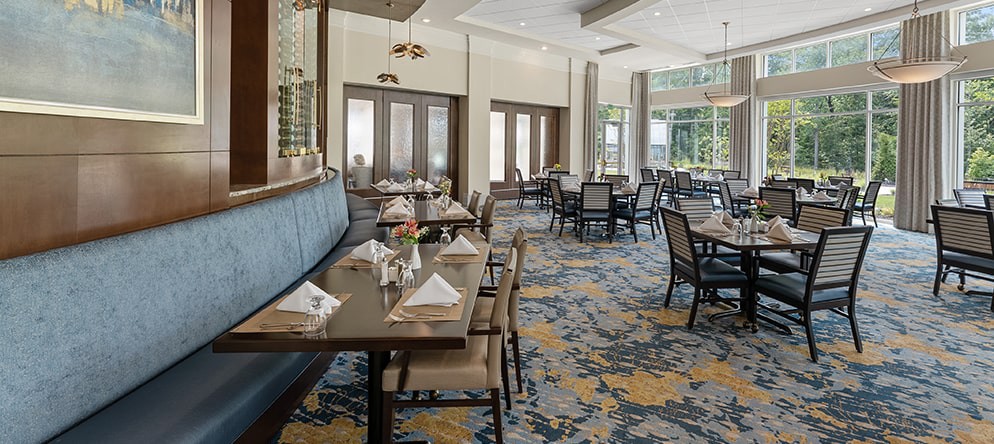 An elegant restaurant dining area with neatly arranged tables and chairs, featuring tasteful interior design.