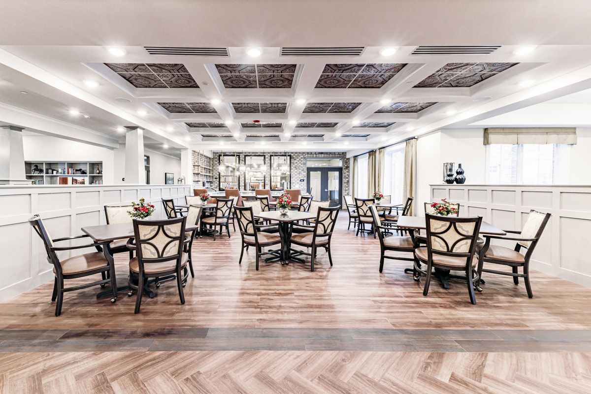 A modern restaurant interior with neatly arranged tables and chairs, featuring elegant decor.
