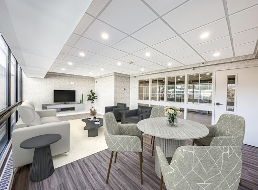 A modern lounge and dining area featuring contemporary furniture and ample lighting.